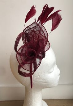 A striking maroon coloured Sinamay fascinator. Crafted from gorgeous maroon Sinamay, this flower and leaf design, finished with Sinamay twists and delicate feathers in the same colour is a striking addition to any outfit! This piece sits comfortably on the head with a co-ordinating satin covered headband. Fascinator measures 19cm x12cm Headband width is 0.5cm Purple Fascinator, Fascinator Hats Wedding, Headband Fascinator, Sinamay Fascinator, Pink Fascinator, Maroon Purple, Hat Fascinator, Wedding Fascinators, Fascinator Hat