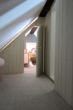 an open door leading to a bedroom with white walls and carpeted flooring on either side of the room