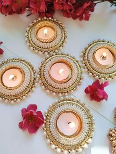 some candles are sitting on a table with flowers