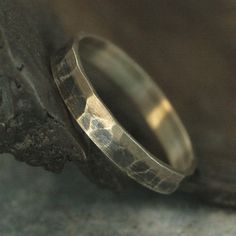 a close up of a wedding ring on a piece of wood with the light reflecting off it's surface