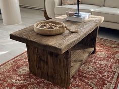 a wooden table with a bowl on top of it in front of a white couch