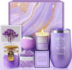 a candle, candles, and other items are arranged in front of a purple box