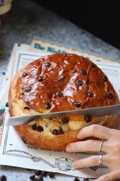 a person holding a knife over a pastry