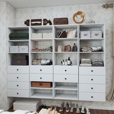 an organized closet with shoes, bags and other items on the shelves in front of it