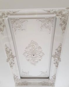 the ceiling is painted white and has ornate designs on it