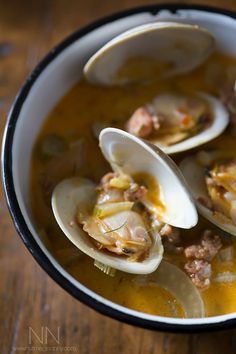 a bowl of soup with clams and meat in it