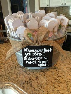 a bucket filled with lots of white plates and silverware sitting on top of a counter