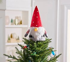 a small christmas tree with a gnome hat on top