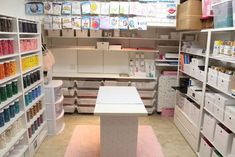 a craft room filled with lots of craft supplies and storage bins on shelving units