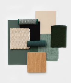 several different shades of green and brown on a white surface with wood, fabric, and paper