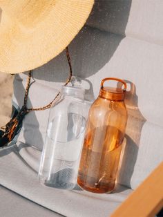 a hat and water bottles sitting on a beach chair