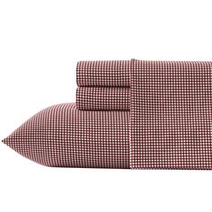 two red and white checkered sheets on top of each other, one with a pillow