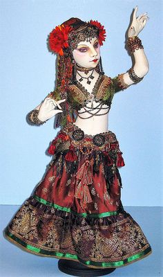 a doll is dressed in an elaborate dress and headdress with flowers on her hair