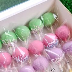 there are many different colored cake pops in the box