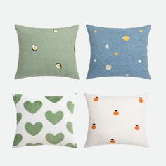 four pillows with hearts on them in various colors and sizes, one is green, the other is blue