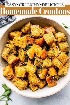 the best croutons recipe in a white bowl with herbs on top and text overlay