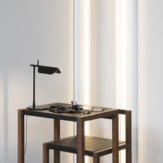 a table with a lamp on it next to two stools and a record player