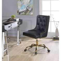 a black desk chair sitting in front of a computer desk with a laptop on it