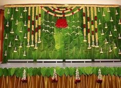 the stage is decorated with green leaves and red flowers