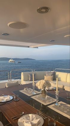 the dining table is set for two on the deck overlooking the ocean and yachts