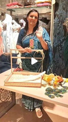 a woman standing in front of a table with some items on it