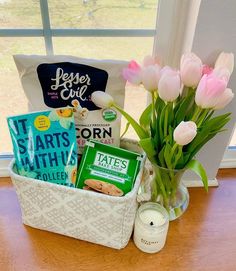 a vase filled with pink tulips sitting on top of a table next to a window