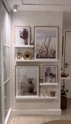 a wall with pictures and other items on it in a room that has white walls