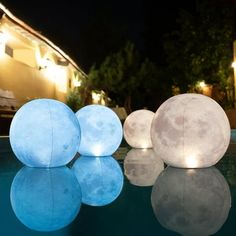 three balls sitting on top of a swimming pool next to each other in the dark