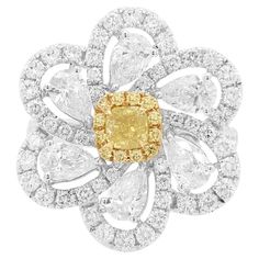 This contemporary 18K Gold ring features a natural Yellow Diamond set at its centre, with a halo of round-shape yellow diamonds. They are perfectly accentuated by the pear-shape and round-shape white diamonds as a floral motif which surrounds it. Unique and striking, this exceptional ring will make the perfect statement each time it is worn. - Centre Diamond, Cushion-shape Yellow Diamond 0.19 carat (color Fancy Yellow, clarity VS) - Round Brilliant Cut Yellow Diamonds total 0.08 carat - Pear-sha Modern Diamond Cocktail Rings, Aquamarine Cocktail Ring, Platinum Diamond Ring, Yellow Diamonds, Pear Ring, Platinum Diamond Rings, Gold Cocktail Ring, Contemporary Ring, Diamond Jewelry Designs