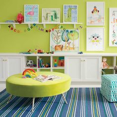 a child's playroom with green walls and pictures on the wall above it