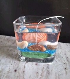 a glass filled with water and seashells