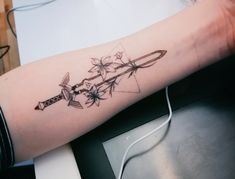 a tattoo on the arm of a woman with an arrow and spider webs attached to it