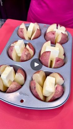 a muffin tin filled with apples and cheese on top of a pink table cloth