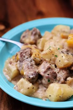 a blue plate topped with potatoes and meat