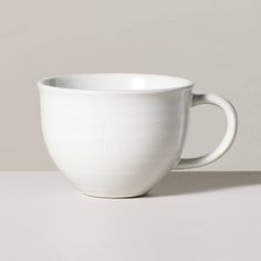 a white cup sitting on top of a table