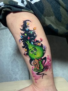 a tattoo on the leg of a person with a christmas tree in her head and hands