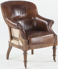 a brown leather chair sitting on top of a white floor next to a wooden frame