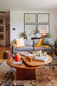 a living room filled with furniture and lots of pictures on the wall above it's coffee table