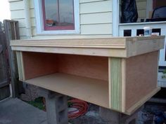 a wooden shelf sitting on the side of a house