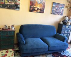 a blue couch sitting in the corner of a room