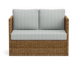 a wicker couch with blue and white striped cushions