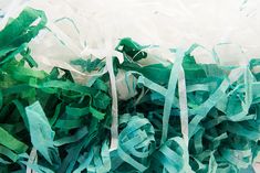 some green and white tissue paper on top of each other with ribbons attached to it