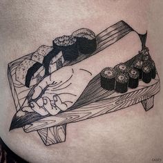 a woman's stomach with sushi and chopsticks tattoo on her belly