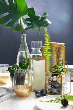 a table topped with vases filled with plants and other decorative items next to each other