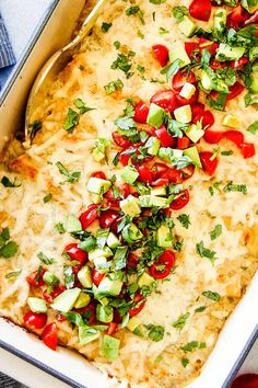 a casserole dish with tomatoes, avocado and cilantro on top