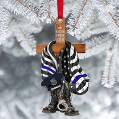 an ornament hanging from a christmas tree with a cross and hat on it