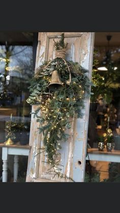 an old door is decorated with greenery and lights