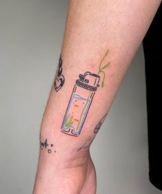 a person with a tattoo on their arm has a drink in the shape of a lighter