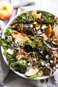 a salad in a bowl with apples and cheese