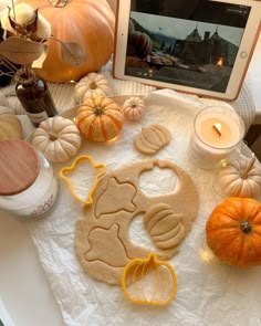 a table topped with pumpkins and cookies next to an ipad